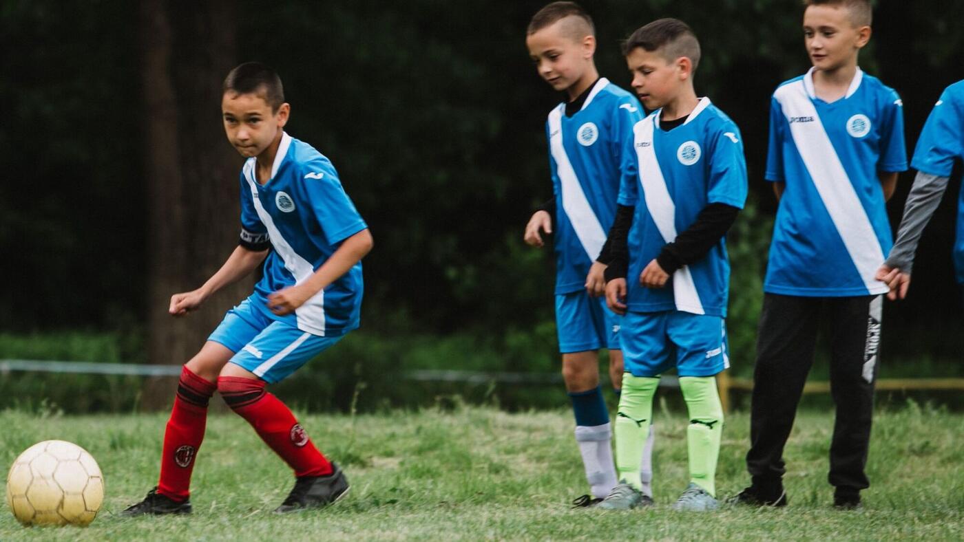 Young soccer players in blue jerseys on the field